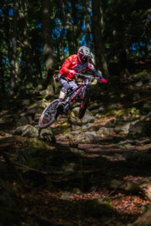 electric MTB in Welsh forest jumping sport action shot