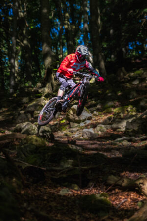 electric MTB in Welsh forest jumping sport action shot