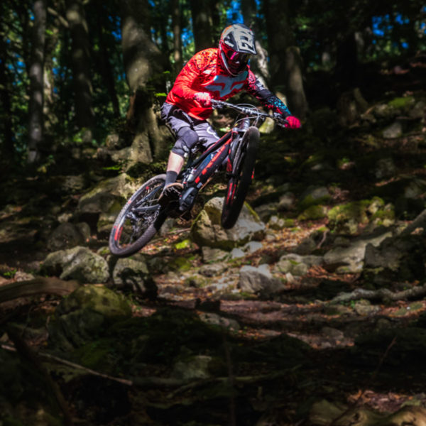 electric MTB in Welsh forest jumping sport action shot