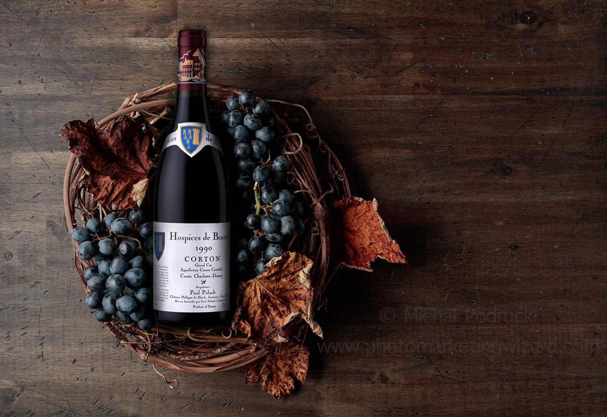 Bottle of red wine Hospices de Beaune 1990 with grapes and dried vine leaves Product photography services Derby