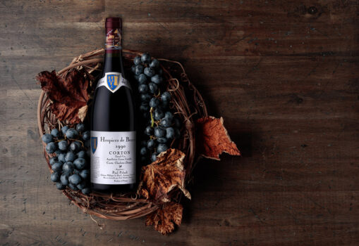 Bottle of red wine Hospices de Beaune 1990 with grapes and dried vine leaves Product photography services Derby